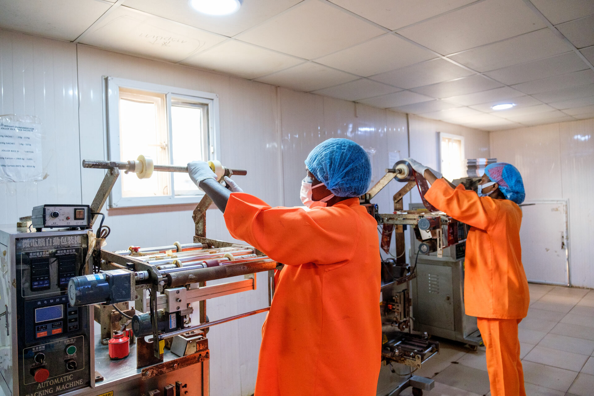 Workers packing food products on an automated line at a partner facility